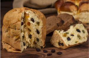 Italy is known all over the world for the culinary delights it offers. It is no secret that these warm homemade delicacies are most magical and captivating when prepared by hand at home. Today we will look at panettone - great for breakfast or dessert with soft and tender, fluffy dough.  To your attention - His Majesty Panettone!   This is a type of Italian sweet bread,  which is something like our Easter cake. It can be said that it is the most emblematic of the Milan region.  It is characterized by its cylindrical shape and in its true form reaches 15-20 cm in height.  Some specimens may exceed 1 kg in weight.    The history of the cake can be traced back to ancient Rome, when it was most often made with honey. During the Holy Roman Empire in the 16th century, the recipe was updated by the famous chef Bartolomeo Scapi. It is believed that the first masters of panettone were Milan bakers.  In the early twentieth century, the cake has gained great popularity throughout Italy.   When is panettone eaten and what distinguishes it from Colombia di Pascha and Brioche?    We have all  seen the cardboard boxes with the inscription panettone,  which have traveled so many kilometers to reach us. Even in Bulgaria it is often offered on the market during the Christmas and New Year holidays. In other countries, including ours, it is sometimes released in stores and around Easter.  For Italians, the consumption of panettone in the spring is a bit unusual. At this time it is more common for them to eat the so-called Easter colombs. These are actually quite similar cakes. They differ from panettone mainly in their shape, but also in the fact that their raisins are replaced by caramelized citrus peels.  To some extent, it can be said that panettone is a variation of the popular Italian kozunak brioche.  The difference between the two is in the cooking time and also in the yeast.  Sweet brioche breads need only a few astronomical hours to rise, while panettone takes more than 50 hours. Also, panettone is mixed with natural yeast, while bread is used for brioche. To swell to an enviable height, they are hooked and hung for a long time.  It is interesting to note that not all panettone is produced in Italy.  Producers and traders from South America and even Asia make a steady income from panettone.  Some Italians are not at all happy about this, as they perceive it as an abuse of their culinary traditions.  That is why there is a  heated political struggle there to give it the status of food with a protected geographical origin  (in Italian abbreviated DOP), as have other typical // dishes in Italian cuisine.// This does not mean that the products and the recipe for this temptation are a secret.  The DOP label would mean that panettone is made only from local products, ie grown in Italy. Unfortunately, this is very difficult in this case, as the country imports most of the flour, sugar, raisins and the huge technological time required for its preparation.  Can we make a mini panettone at home?  Fortunately, there is a way to make sweet, small panettone cakes completely on your own and without going through 50 hours of preparation.  Products  We will need:  •	500 g flour (type 500) •	200 g of soft butter •	2 whole eggs, 1 more yolk separately •	1 tsp vanilla •	200 ml of warm milk •	100 g powdered sugar •	150 g raisins •	pinch of salt. •	In this case we will use 2 packets of dry yeast, 30 g of almond flakes.    Method of preparation  •	Beat the two egg whites and the three egg yolks with the vanilla.  We prepare a large bowl in which to mix the dry products - flour, yeast, sugar and a pinch of salt. •	Then  add the eggs and milk  to the mixture, starting to stir with a wooden spoon until a sticky dough is obtained. Now we have to cover it with kitchen foil, put it warm and wait for it to double in size. •	After the first rising, it is time to add the butter and raisins. Then divide the dough into small balls and leave them to rise for the last time before baking. •	Now we can  turn on the oven at 180 degrees  and finalize our mini panettone. We use paper muffin tins. It is best to put them in a silicone or metal mold so that they do not spread. •	Before we start baking, spread the mini cakes with milk. They need  about 30 minutes to be ready.      When cool, fluffy panettone muffins are ready to serve . You can offer them to your guests with a spoonful of the famous  Italian gelato or mascarpone,  served on the side, and a topping of chocolate, syrup or marmalade, or you can turn them into real cupcakes by placing cream and topping directly on them. They can be eaten for breakfast with a cup of coffee or hot chocolate, and also as a dessert or snack in the afternoon.  They go well with Italian wine in the evening. 